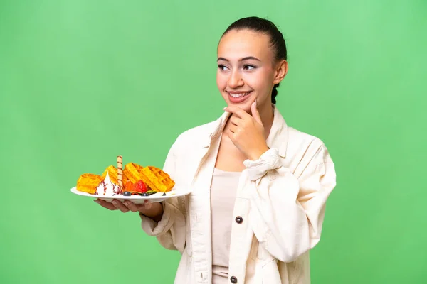 Zole Edilmiş Arka Planda Waffle Tutan Genç Bir Arap Kadın — Stok fotoğraf