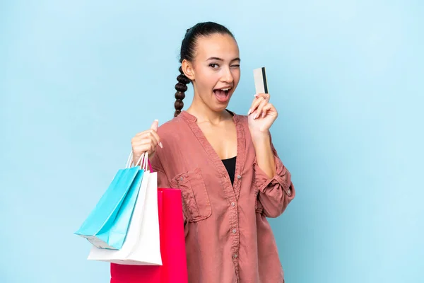 Ung Arabisk Kvinna Isolerad Blå Bakgrund Håller Shoppingväskor Och Ett — Stockfoto