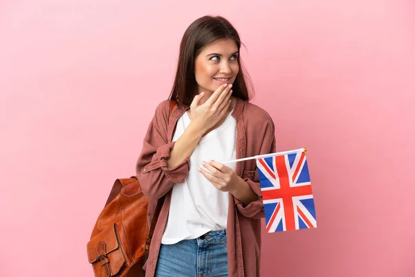 Mladá Běloška Drží Vlajku Spojeného Království Izolované Růžovém Pozadí Vzhlíží — Stock fotografie