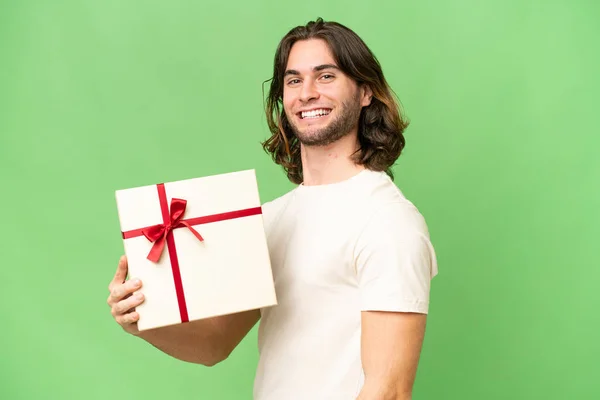 Jonge Knappe Man Met Een Geschenk Geïsoleerde Achtergrond Glimlachen Veel — Stockfoto
