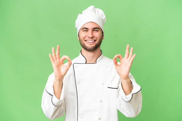 Młody Przystojny Szef Kuchni Człowiek Odosobnione Tło Pokazując Znak Palcami — Zdjęcie stockowe
