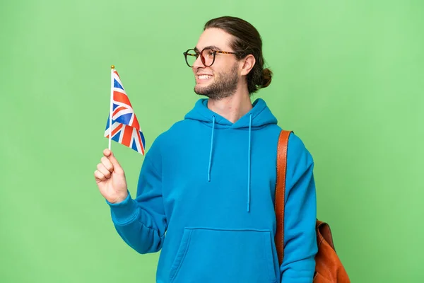Mladý Pohledný Muž Drží Britskou Vlajku Nad Izolované Pozadí Hledá — Stock fotografie