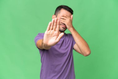 Soyutlanmış geçmişi olan yakışıklı beyaz bir adam jesti durdurup yüzünü kapatıyor.