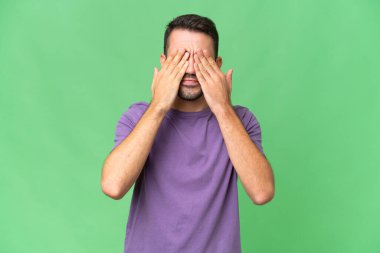 Genç, yakışıklı, beyaz bir adam izole edilmiş bir geçmişi var. Gözlerini elleriyle kapatıyor.