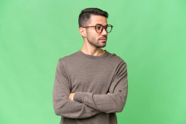 Soyutlanmış geçmişi olan yakışıklı beyaz bir adam kollarını kavuşturuyor.