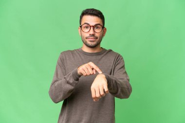 Soyutlanmış geçmişi olan yakışıklı beyaz bir adam geç kalma jesti yapıyor.