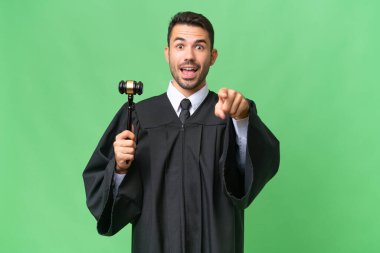 İzole edilmiş geçmişi olan beyaz bir yargıç şaşırmış ve ön tarafı işaret ediyor.