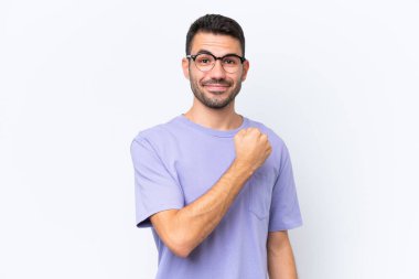 Beyaz arka planda izole edilmiş genç beyaz adam zaferi kutluyor.