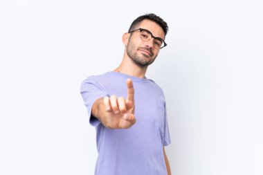 Beyaz arka planda izole edilmiş genç beyaz adam parmağını kaldırıyor ve gösteriyor.