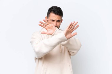 Beyaz arka planda izole edilmiş genç beyaz bir adam sinirleri gergin ve ellerini öne uzatıyor.