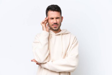 Beyaz arka planda başı ağrıyan genç beyaz bir adam.