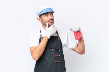 Kasap beyaz önlük takmış ve izole edilmiş beyaz arka planda taze et servis ediyor.