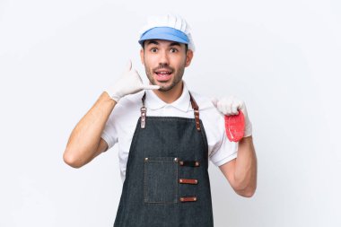 Kasap beyaz önlük takmış ve telefon hareketleriyle izole edilmiş beyaz arka planda taze et servis ediyor. Bana geri dönüş işareti ver.