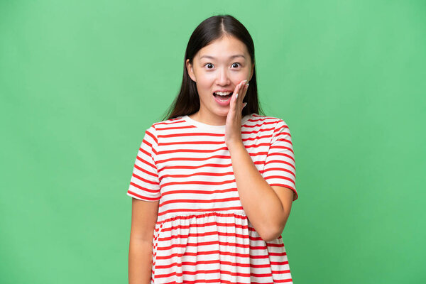 Young Asian woman over isolated background with phone in victory position