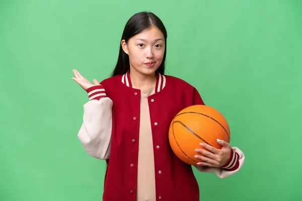 Jonge Basketbalspeler Aziatische Vrouw Geïsoleerde Achtergrond Met Twijfels Terwijl Het — Stockfoto