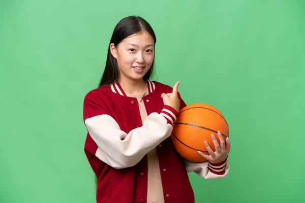Jonge Basketbalspeler Aziatische Vrouw Geïsoleerde Achtergrond Wijzend Terug — Stockfoto