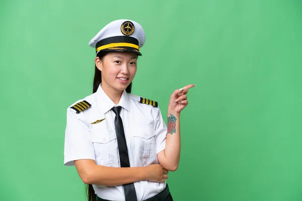 비행기 조종사인 아시아 여자가 배경을 가리키며 가리키고 — 스톡 사진