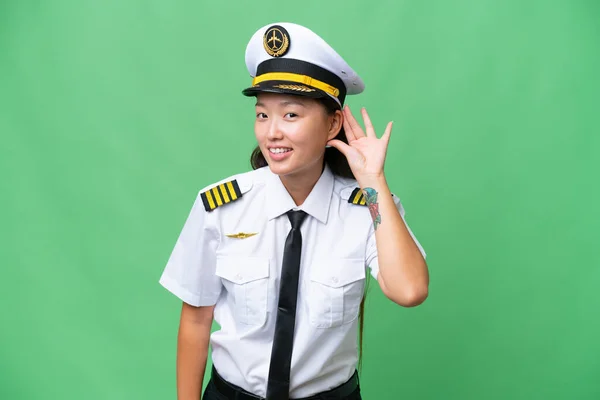 Airplane Pilot Asian Woman Isolated Background Listening Something Putting Hand — Foto Stock