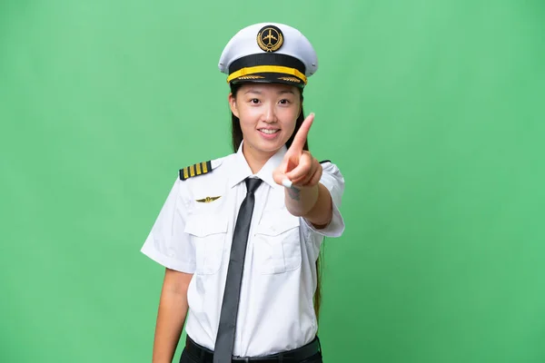 飞机驾驶员亚洲妇女克服孤立的背景 展示和举起一个手指 — 图库照片