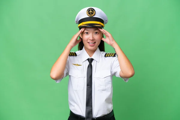 飞机驾驶员亚洲女人带着惊奇的表情越过孤立的背景 — 图库照片