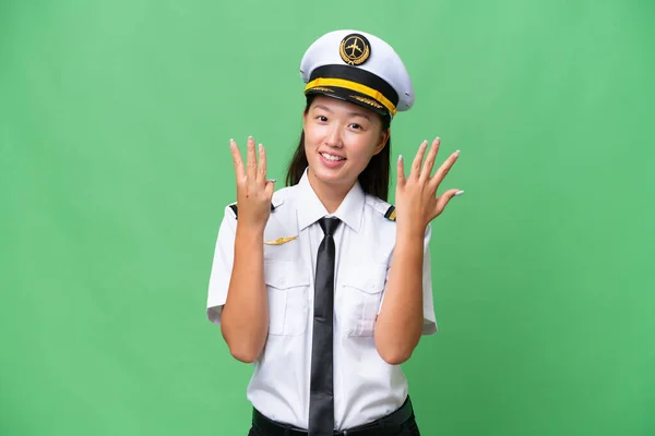 飞机驾驶员亚洲女人在孤立的背景下用手指数着8 — 图库照片