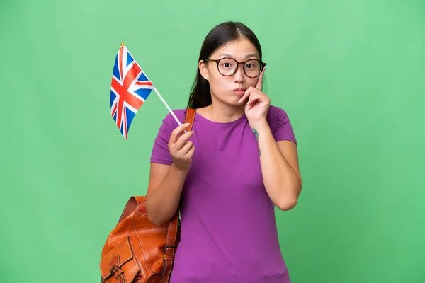 Молода Азіатка Тримає Прапор Великої Британії Над Ізольованим Тлом Думаючи — стокове фото