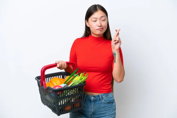 年轻的亚洲女人手里拿着一篮子用白色背景隔开的食物 手指头叉着 祝福好运 — 图库照片