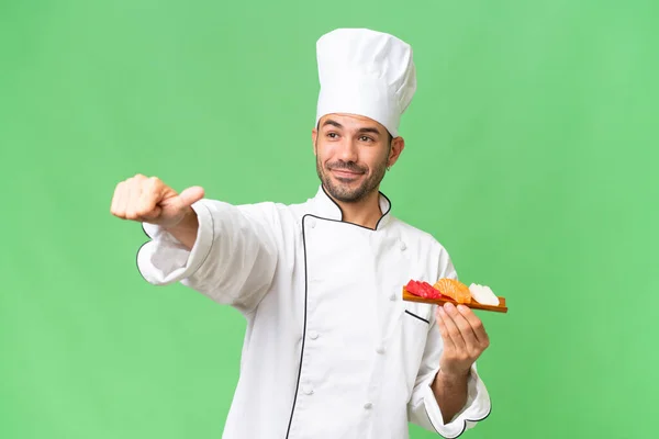 Junger Kaukasischer Koch Der Ein Sushi Über Isolierten Hintergrund Hält — Stockfoto