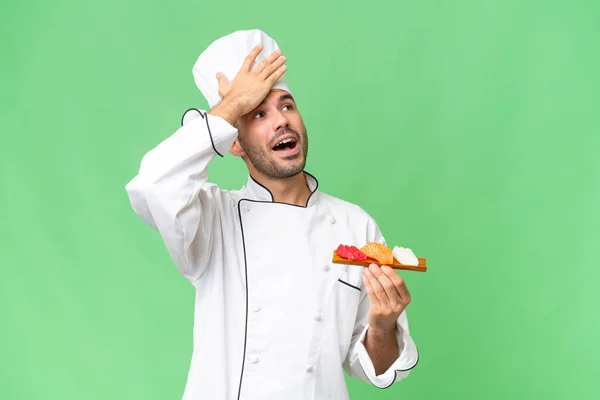 Jovem Chef Caucasiano Segurando Sushi Sobre Fundo Isolado Percebeu Algo — Fotografia de Stock