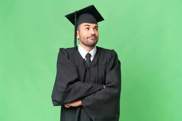 Jovem Universitário Graduado Homem Sobre Fundo Isolado Fazendo Gestos Dúvidas — Fotografia de Stock