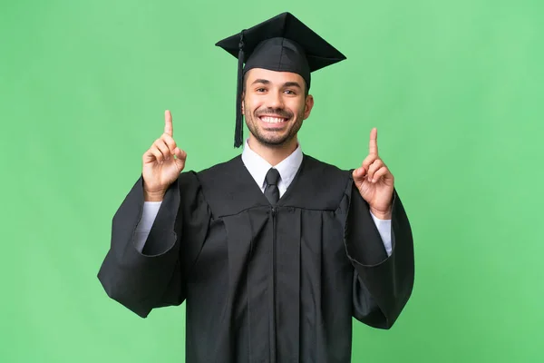 Jovem Universitário Graduado Homem Sobre Isolado Fundo Apontando Para Uma — Fotografia de Stock