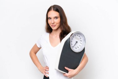 Beyaz arka planda tartı makinesiyle izole edilmiş beyaz bir beyaz kadın.