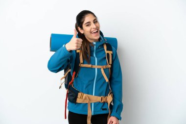 İzole edilmiş arka planda büyük bir sırt çantasıyla genç dağcı. Başparmakları havada. Çünkü iyi bir şey oldu.