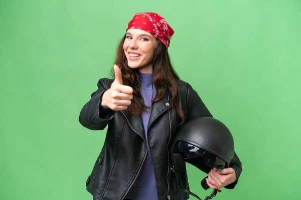 若いですCaucasian女性とともにオートバイヘルメット上の隔離された背景とともに親指アップ何か良いことが起こっているので — ストック写真