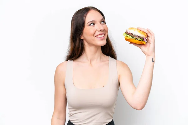 Young Caucasian Woman Holding Burger Isolated White Background Looking While — Foto de Stock