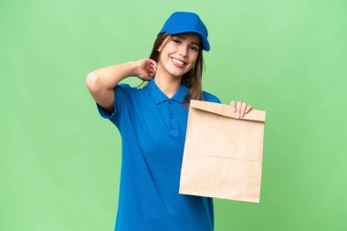 Young beautiful caucasian woman taking a bag of takeaway food over isolated background laughing