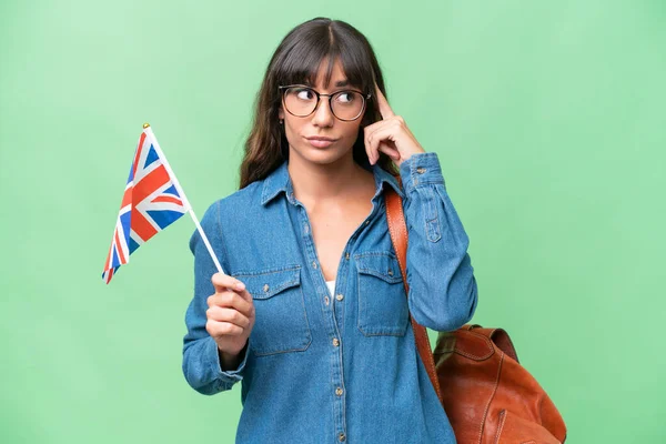 Mladá Běloška Drží Britskou Vlajku Nad Izolovaným Pozadím Pochybuje Přemýšlí — Stock fotografie