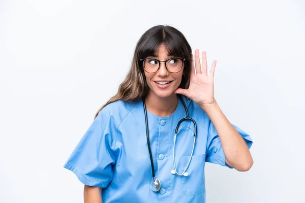 耳に手を置くことによって何かを聞く白い背景に隔離された若い白人看護師の女性 — ストック写真