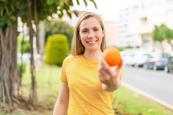 Mladá Blondýnka Drží Pomeranč Venku Šťastným Výrazem — Stock fotografie