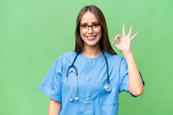 若いです看護師Caucasian女性上の隔離された背景ショーOk Signとともに指 — ストック写真