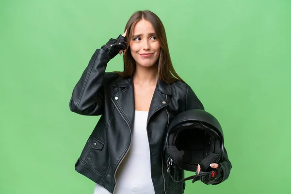 年轻漂亮的高加索女人 头戴摩托车头盔 背景偏僻 有怀疑和思考 — 图库照片