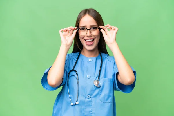 Junge Krankenschwester Kaukasische Frau Über Isolierten Hintergrund Mit Brille Und — Stockfoto