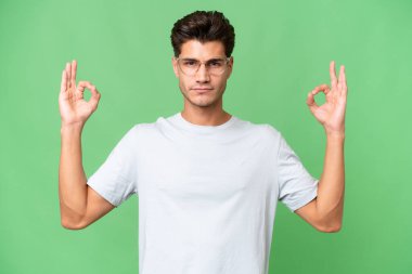 Zen pozunda soyutlanmış beyaz, yakışıklı genç bir adam.