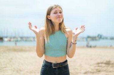 Açık havada genç sarışın bir kadın şüpheli hareketler yapıyor.