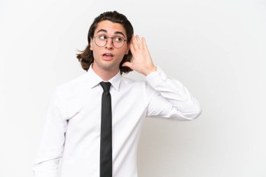 Beyaz arka planda izole edilmiş yakışıklı bir iş adamı. Kulağına elini sürerek bir şeyler dinliyor.