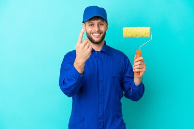 Kafkasyalı ressam mavi arka planda izole edilmiş bir şekilde el hareketi yapıyor.