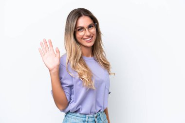 Genç Uruguaylı kadın beyaz arka planda izole edilmiş mutlu bir ifadeyle selamlıyor.