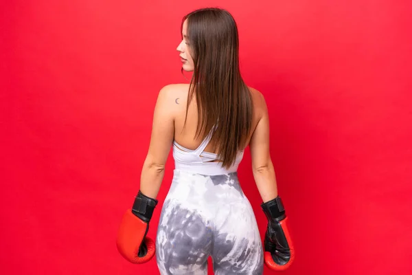年轻美丽的高加索女人 戴着拳击手套 与红色背景隔离 — 图库照片