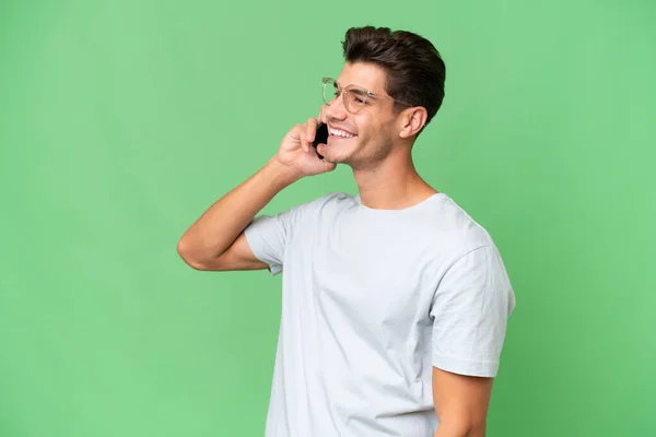 Young Caucasian Handsome Man Isolated Background Keeping Conversation Mobile Phone — Stock Photo, Image