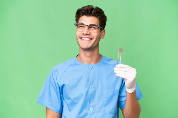 Jovem Dentista Homem Segurando Ferramentas Sobre Fundo Isolado Pensando Uma — Fotografia de Stock